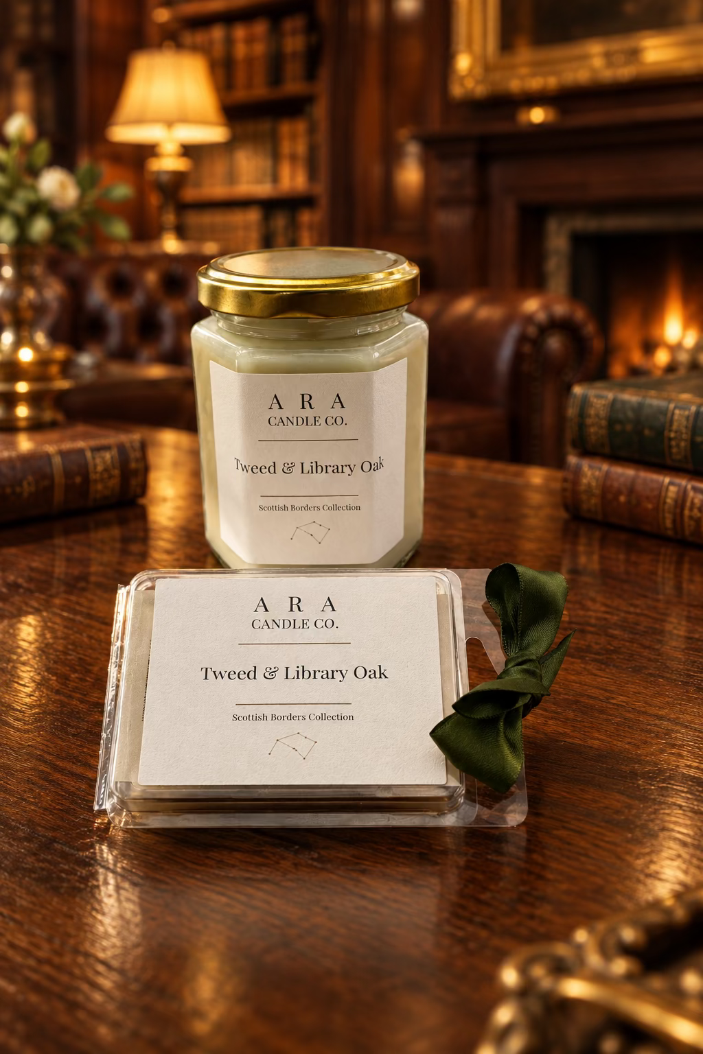 A jar candle and a box of scented candles from ARA Candle Co. in the 'Tweed & Library Oak' scent, displayed on a wooden table with a green ribbon.